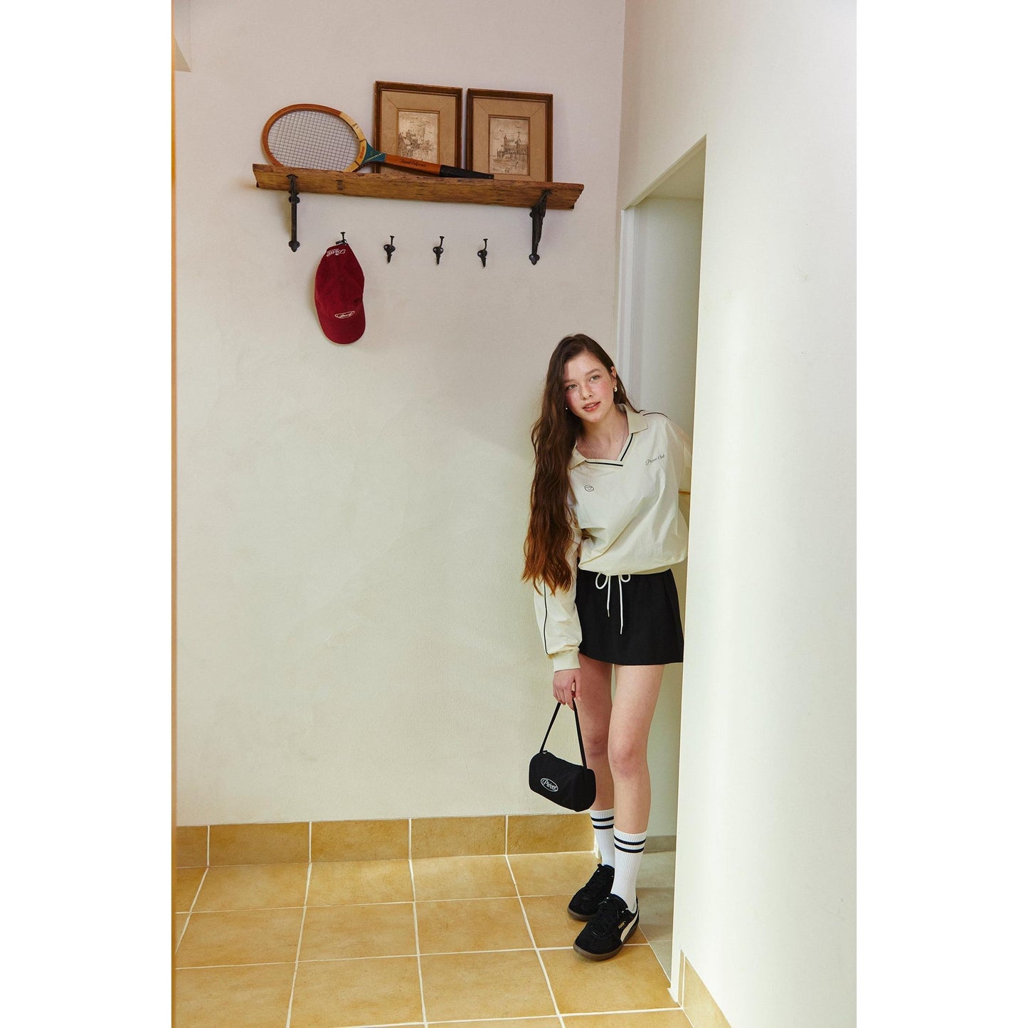 model wearing piv'vee club piste top with stylish shorts in a minimalist hallway