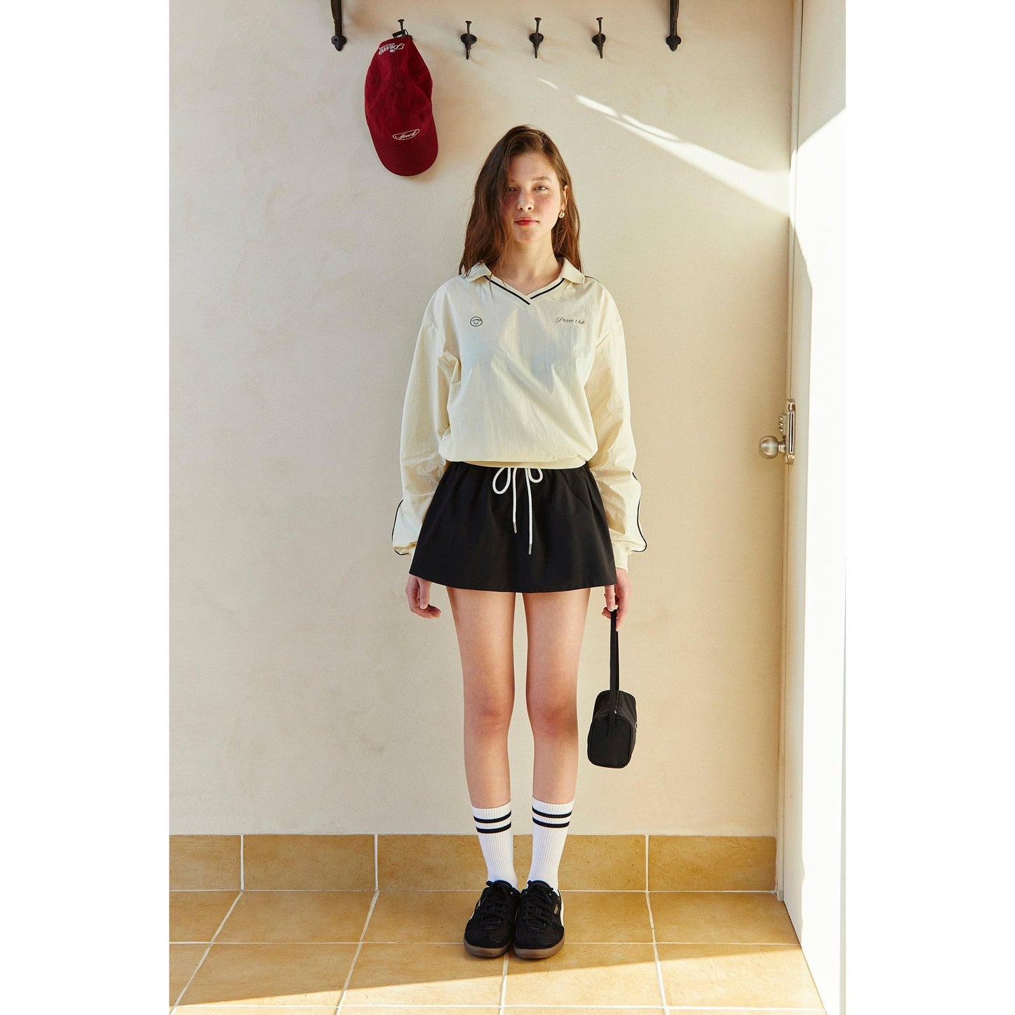 piv'vee club piste top in cream with drawstring detail, paired with a black skirt for a stylish look