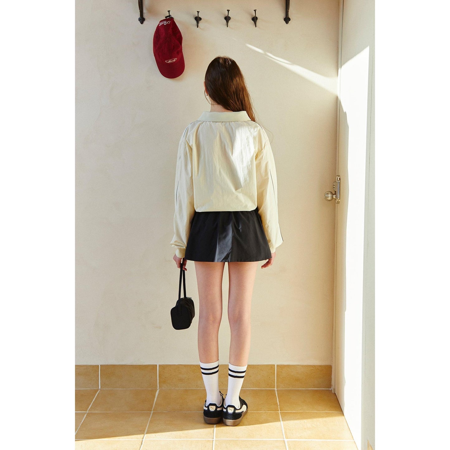 piv'vee club piste top in cream with oversized fit, paired with a black skirt for a stylish look