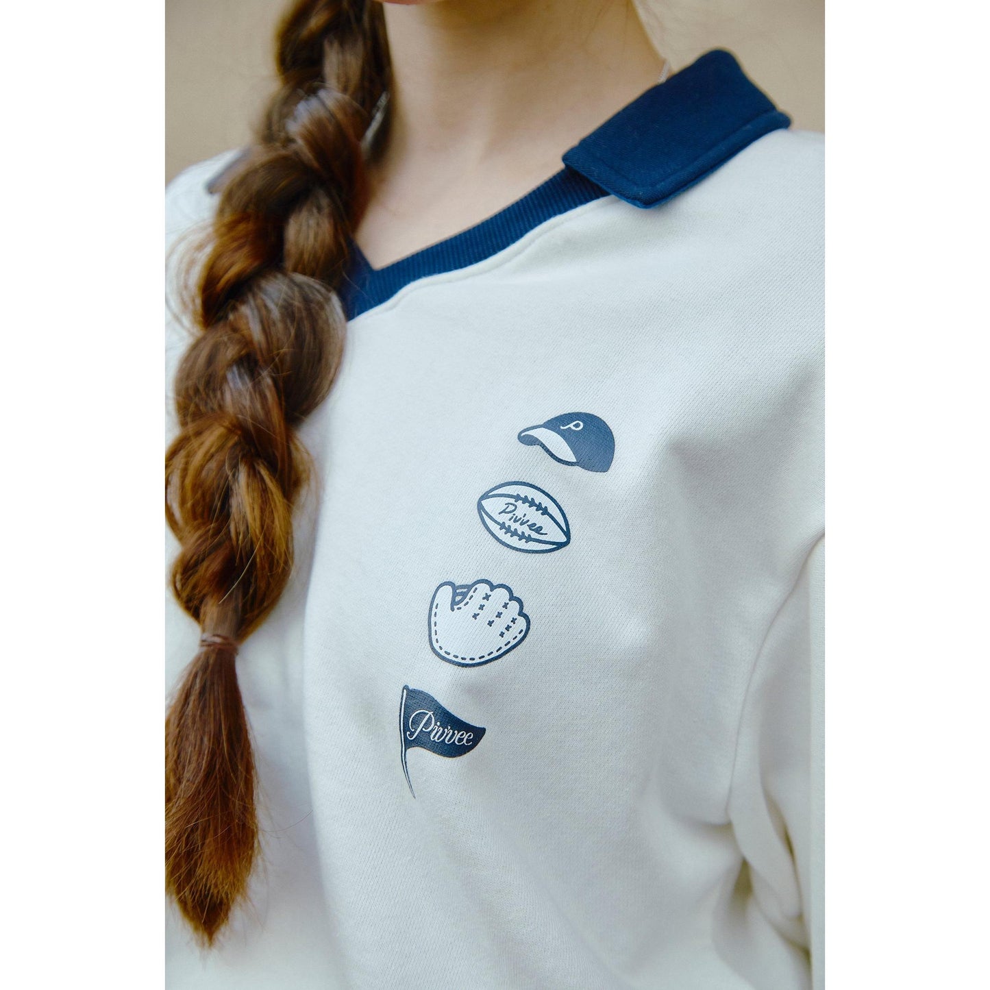 piv'vee v neck golf sweatshirt in cream with navy collar and playful graphics on the front